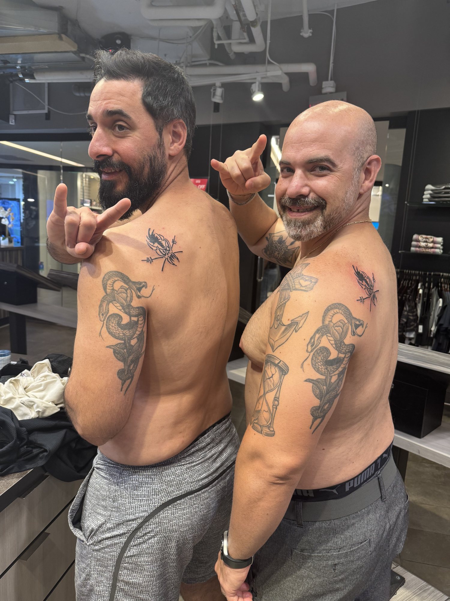 Two friends showing their matching fresh Metallica shoulder tattoos, tattooed by Melissa Zurisk at Club Tattoo in Las Vegas