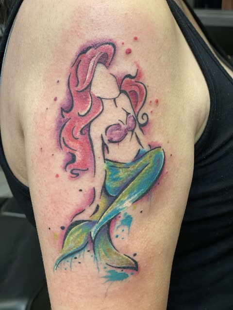 Red haired mermaid tattoo in watercolor washes on an upper arm