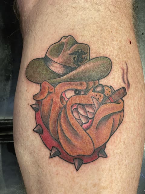 Bulldog tattoo in a campaign hat with a cigar and spiked collar, full color, on a calf