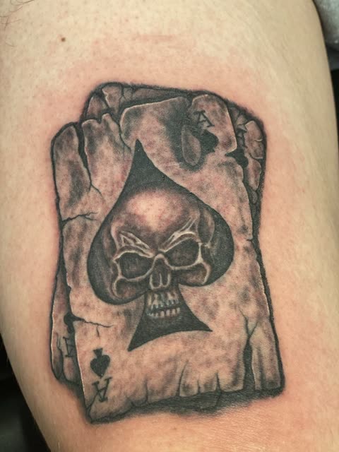 Ace of spades tattoo with a skull inside the spade, black shading